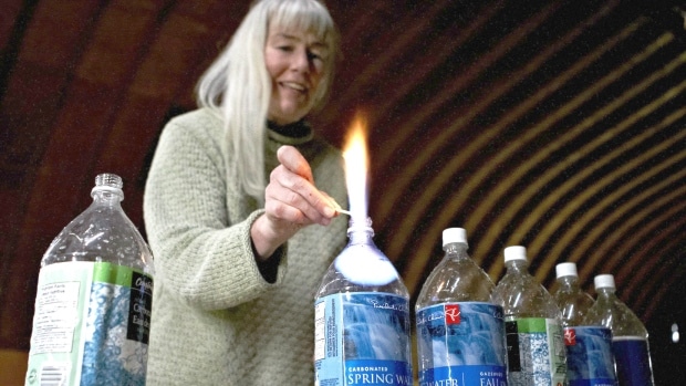 Jessica Ernst burns off some of the methane that is in her well water in Rosebud, Alta. (Jeff McIntosh/Canadian Press)