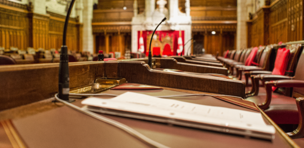 Photograph of Senate Chamber with microphone and paperwork in foreground and chairs in background